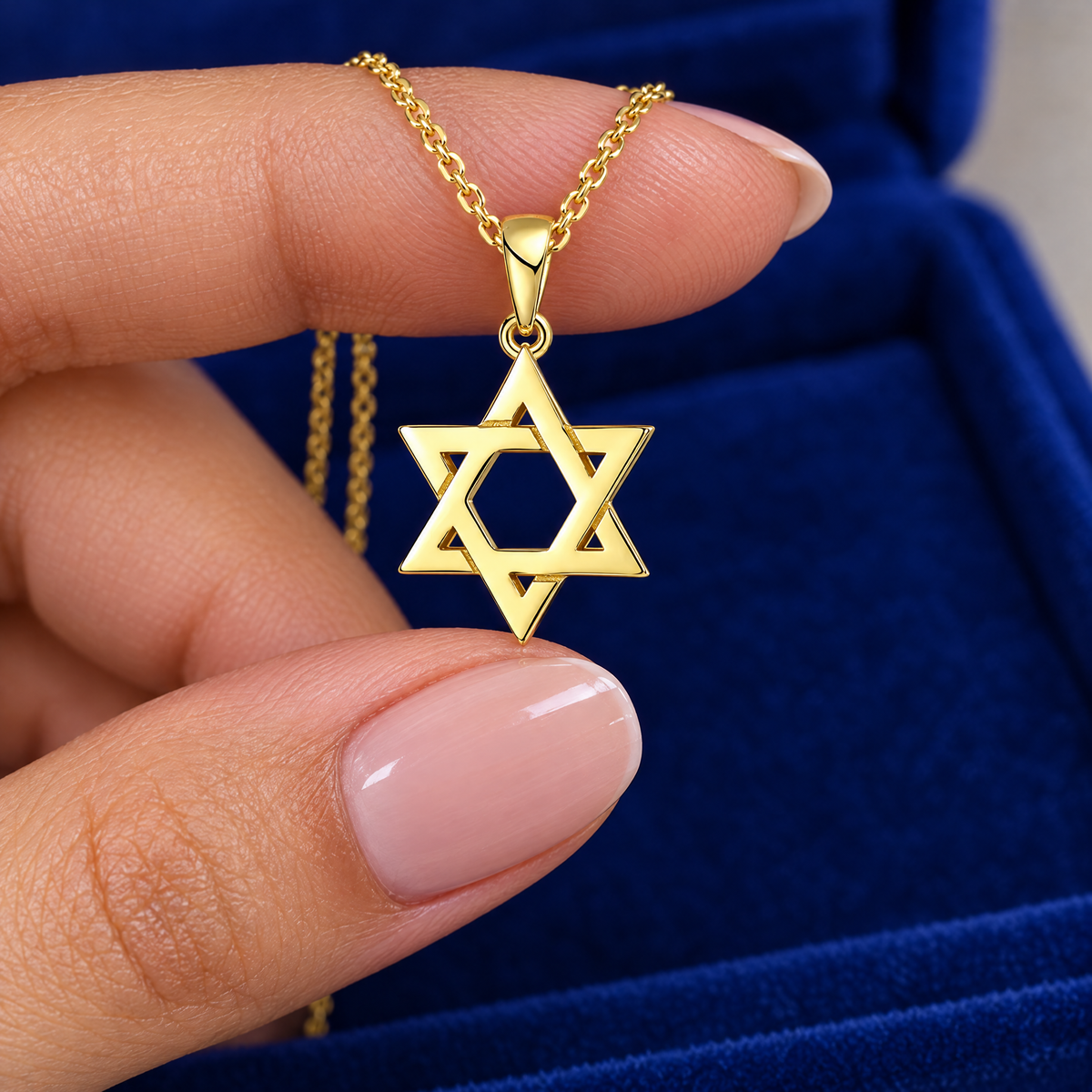 Gold Magen David necklace in sterling silver in the hand, to show its real size (20 x 12 mm)