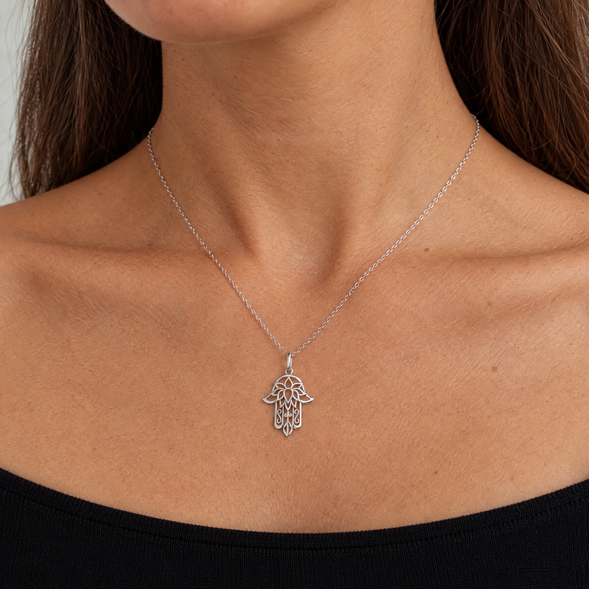 Lace hamsa necklace in sterling silver worn, shown at real size (27 x 19.5 mm)