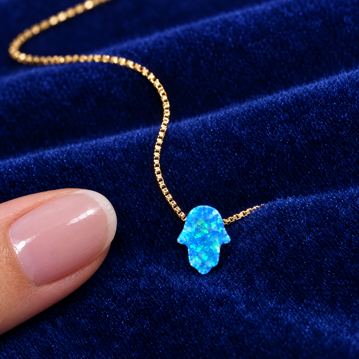 Blue opal hamsa necklace on royal blue velvet