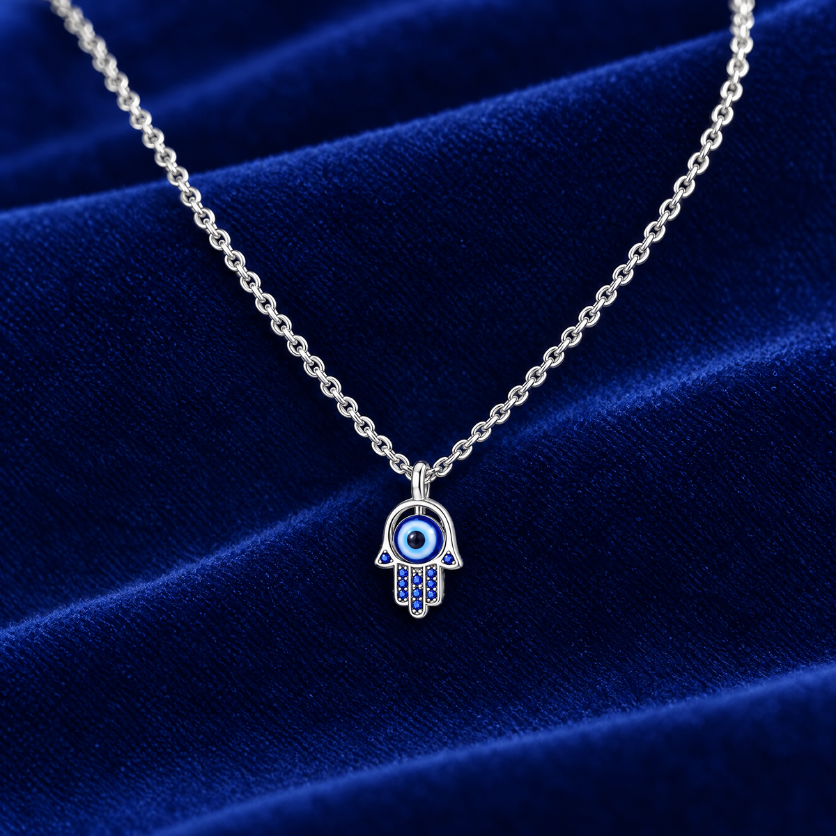 Sterling silver hamsa necklace with blue eye on royal blue velvet