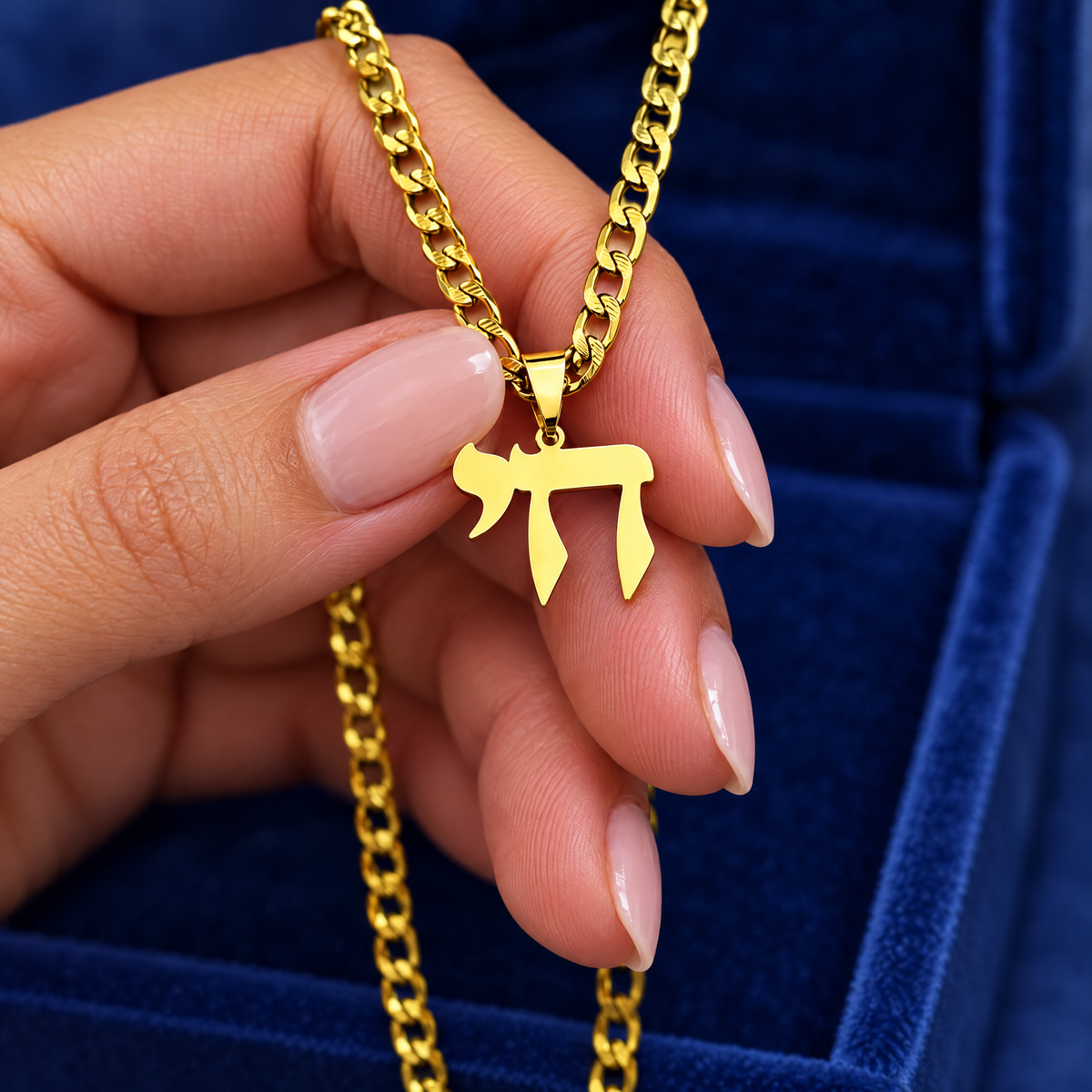 Gold Chai necklace in the hand, to show its real size (20 x 26 mm)