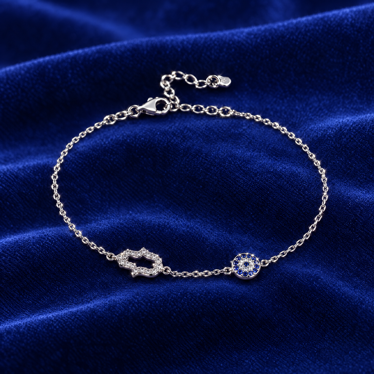 Hamsa and blue eye bracelet in sterling silver on royal blue velvet