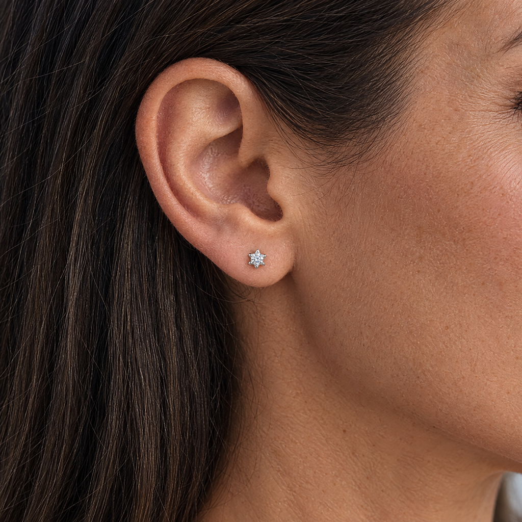 Moissanite star stud earring worn, shown at real size (6 mm)