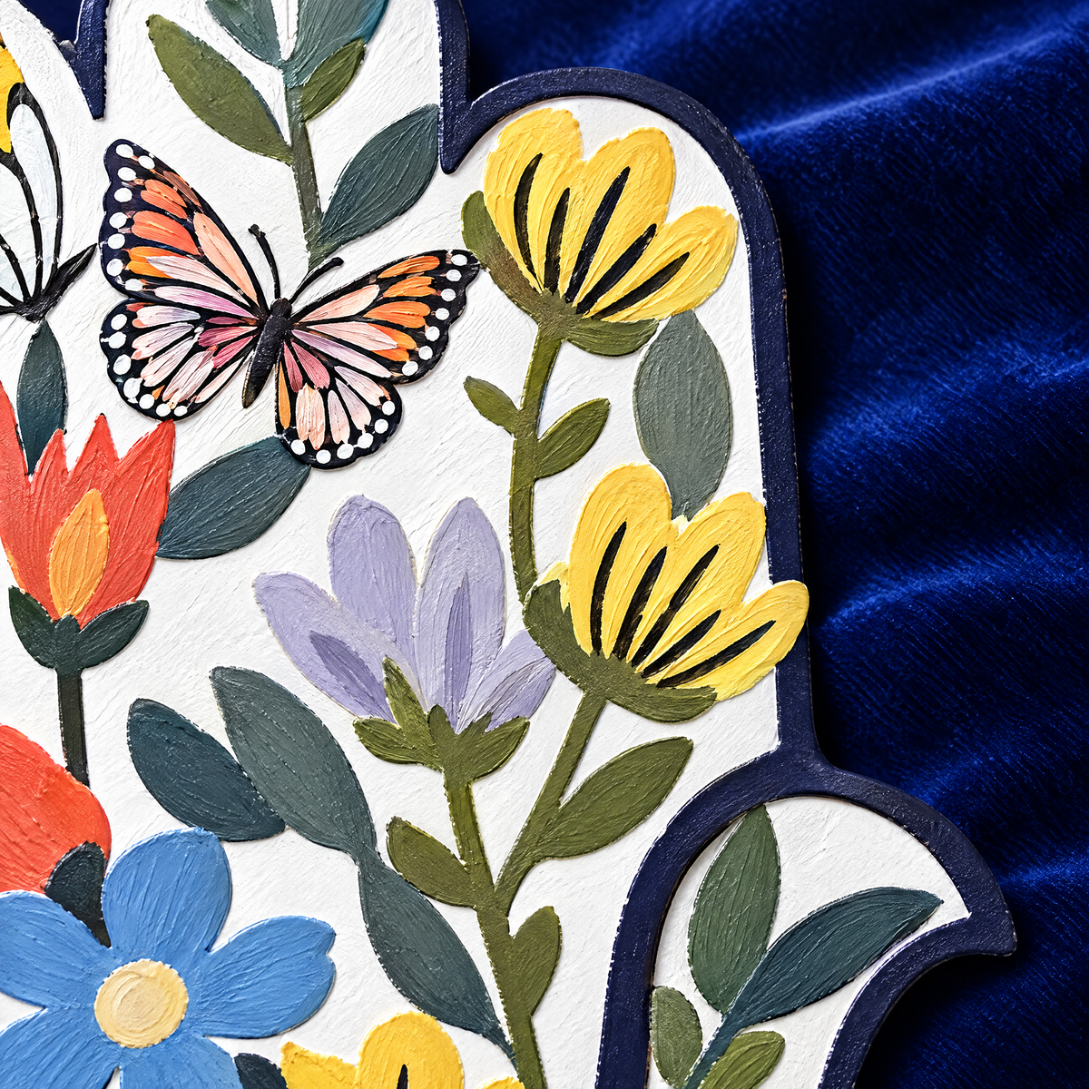 Painted iron hamsa wall art, close-up of the painted flowers