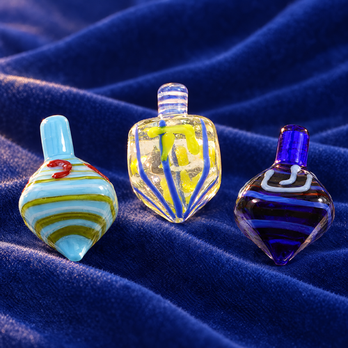 Glass dreidel set of 3 on royal blue velvet